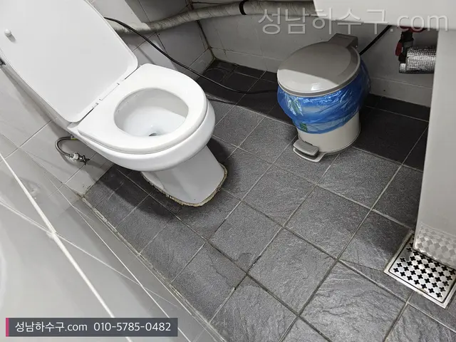 상가 화장실의 변기와 바닥 배수구