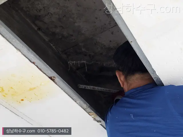 천장 점검구 안을 살피는 기술자