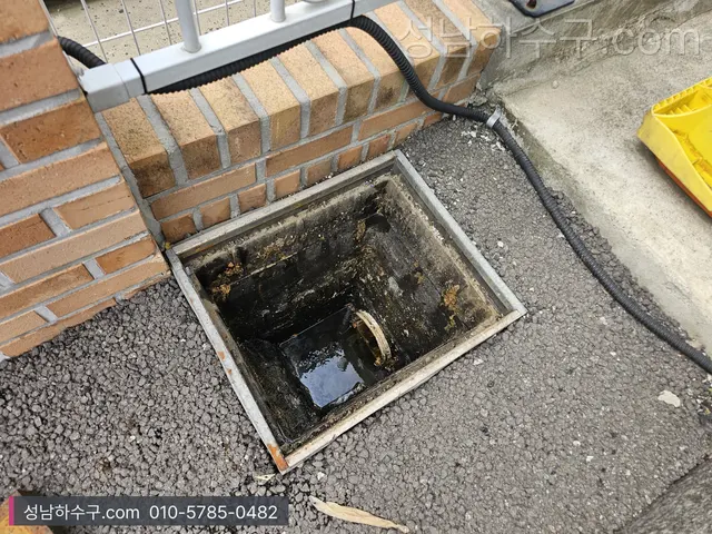 건물 외벽 우수받이 그레이팅 아래 쌓인 흙과 이물