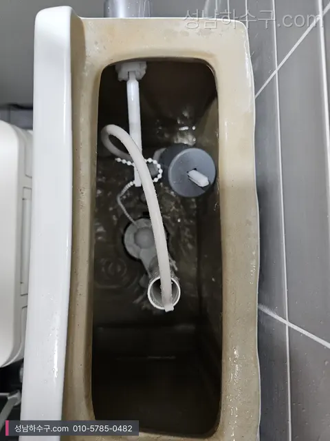뚜껑을 연 변기 물탱크 안의 필밸브·급수호스·플로트